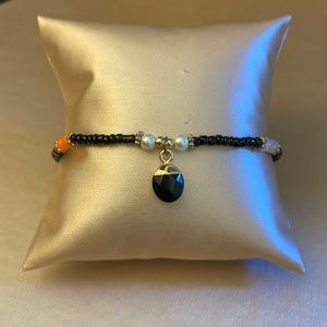 Brand new stretchy beaded bracelet with black jewel charm